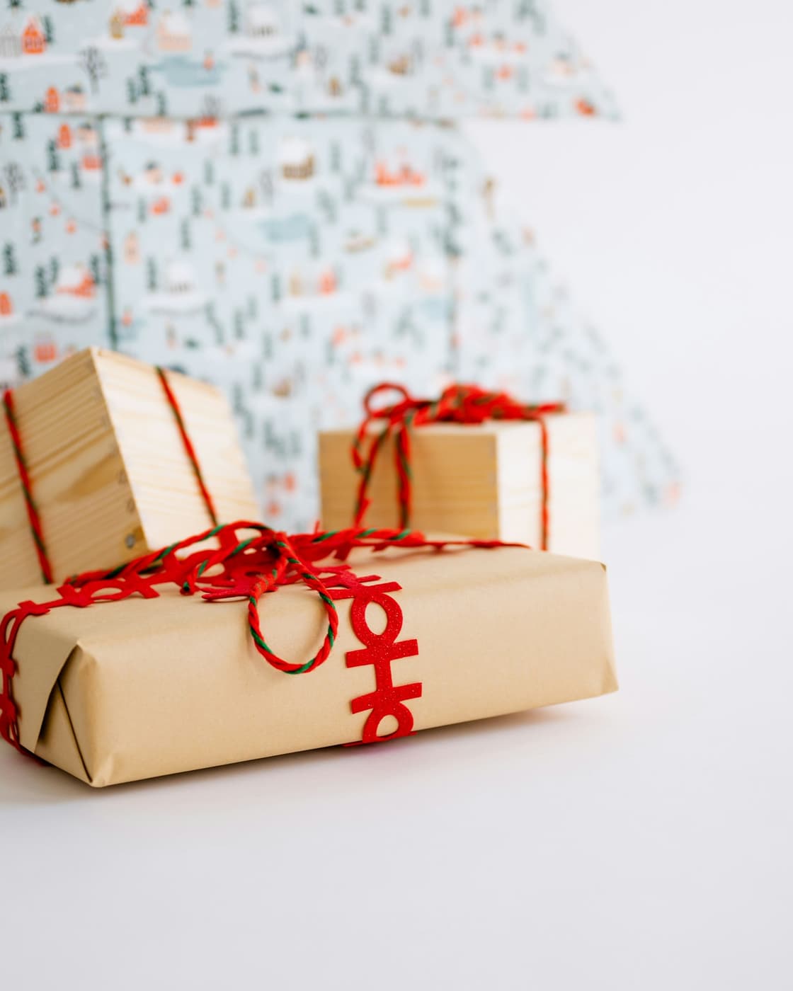 Presents wrapped in kraft paper and tied with red string.